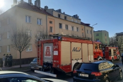 Pojazdy Państwowej Straży Pożarnej przy budynku mieszkalnym wielorodzinnym, w którym doszło do pożaru