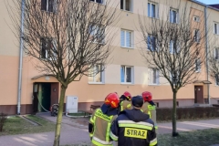 Strażacy przed budynkiem, w którym doszło do pożaru