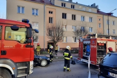 Strażacy przed budynkiem, w którym doszło do pożaru
